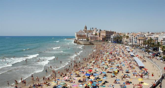 Tourists enjoying San Sebastiá beach in Sitges, Catalonia