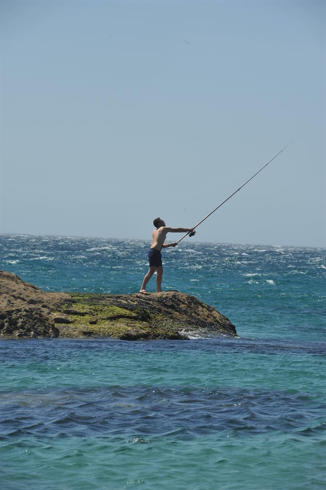 Pescador con caña en el Cabo de Plata, playa de los alemanes, Zahara