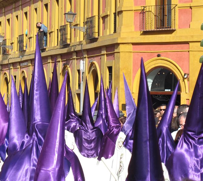 Purple-robed nazarenos in Semana Santa procession